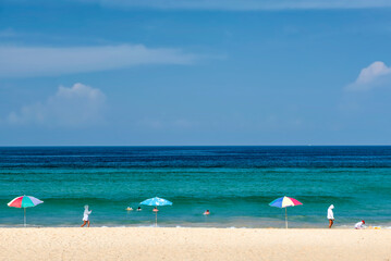 Tourists on the white sand of Karon Beach in Summer, Phuket, Thailand