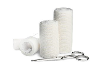 Medical bandage rolls, sticking plaster and scissors on white background