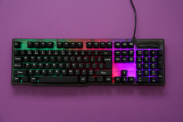Modern RGB keyboard on purple background, top view
