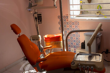 Dentist chair in orange color and dentists equipment