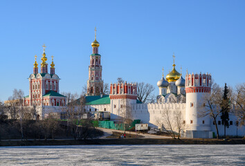 Fototapeta na wymiar View of the fortress walls and temples of the Novodevichy Monastery with golden domes in Moscow, Russia