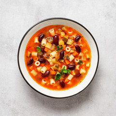 Vegetarian minestrone italian soup made with fresh vegetables, pasta and beans. Light gray background, top view