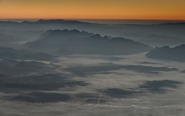 Fluffy sea of fog in a valley at sunrise time