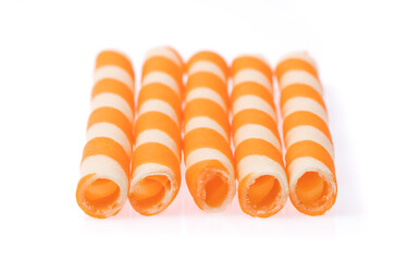 Striped wafer rolls filled with orange isolated on white background