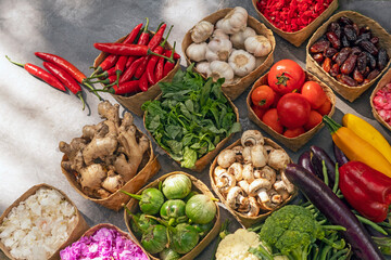 Fresh vegetables from organic farm in eco-friendly containers made from natural materials on gray background. Copy space