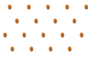 A pattern of oval caramel candies on a white background.