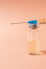 syringe, ampoule on a beige background, vaccination concept..