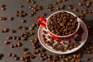 red cup with coffee beans on dark background