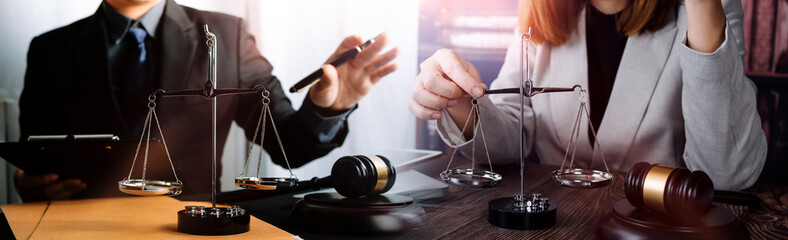 Business and lawyers discussing contract papers with brass scale on desk in office. Law, legal services, advice, justice and law concept