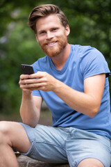 young man in the countryside using a smartphone