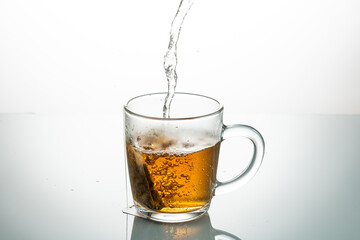 making tea from a tea bag in a transparent mug on a white background