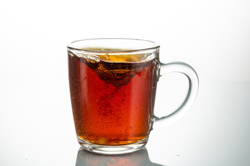 stir with a spoon a piece of sugar in a transparent mug on a white background