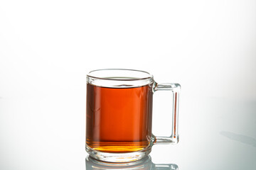 making tea from a tea bag in a transparent mug on a white background