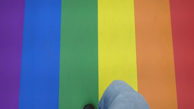 Walking on rainbow colored floor. Red, orange, yellow, green, blue, and violet are the colors of LGBT pride flag.