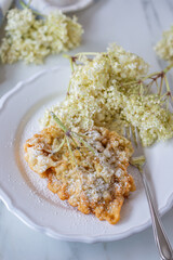 Sweet home made fried elderflowers in pancake on a table