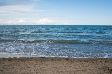 Sandy natural coastline and waves