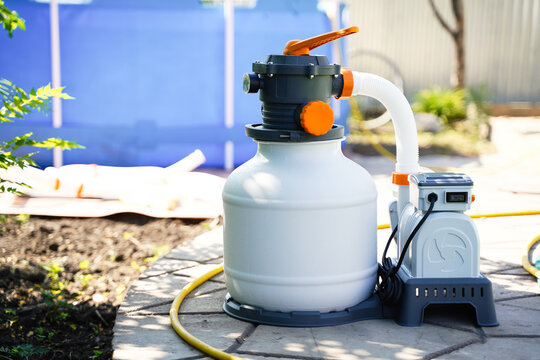 Sand filter system for purifying pool water on the background of a frame polyethylene pool