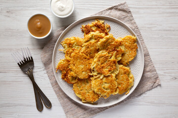 Homemade Potato Pancakes Latkes with Apple Sauce and Sour Cream on a white wooden background, top view. Flat lay, overhead, from above.