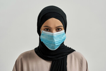 Portrait of young arabian girl in hijab and mask