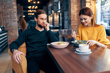 cheerful young couple sitting in a restaurant rest eating
