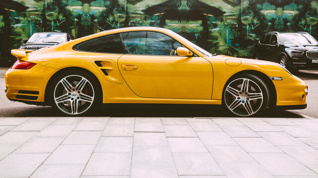 Yellow Porsche 997 Turbo Car Parked On The Street In The City. Porsche 911 Side View