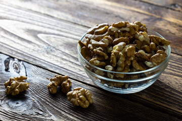 walnuts on a table. peeled walnuts in a glass bowl on a wooden table
