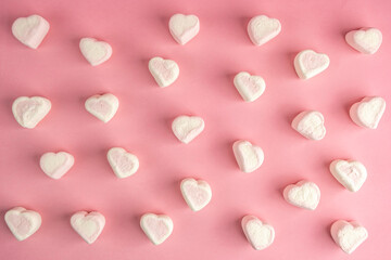 Marshmallow hearts on pink background.