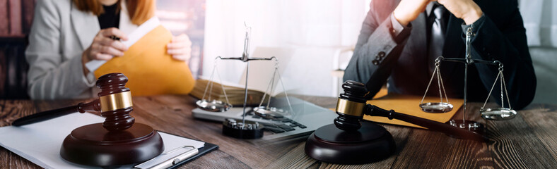 Justice and law concept.Male judge in a courtroom with the gavel, working with, computer and docking keyboard, eyeglasses, on table in morning light