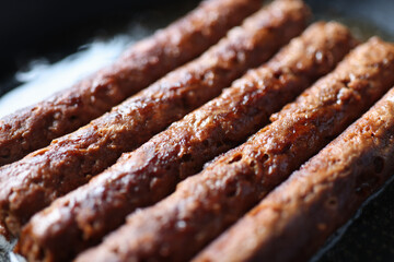 Pork sausages are fried in pan closeup