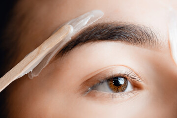Closeup Master wax depilation of eyebrow hair in women, brow correction - obrazy, fototapety, plakaty