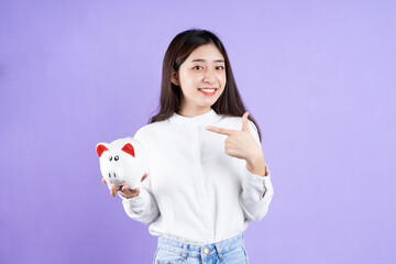 woman with piggy bank, isolated on purple background