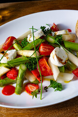 Asparagus salad with strawberries, tomatoes and goat cheese