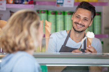 man serving female customer in an ice-cream parlour