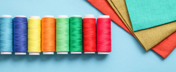 Sewing and objects for sewing. Colorful Fabrics, Thread, on blue background. Long banner