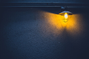 The light and shadow background of the old street lamp on the back street wall