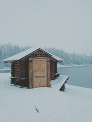 frozen sauna cabin by the frozen lake in winter