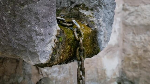 Eine Kette, &uuml;ber die das Wasser aus einem Brunnen abflie&szlig;en kann
