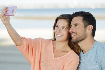 happy traveling couple making selfie sea background