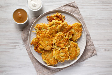 Homemade Potato Pancakes Latkes with Apple Sauce and Sour Cream on a white wooden table, top view. Flat lay, overhead, from above.