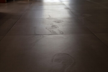 Footprints on dirty floor and background of light.