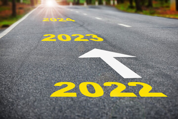 Direction to new year concept and sustainable development idea. Number of 2022 to 2024 on asphalt road surface with marking lines. 