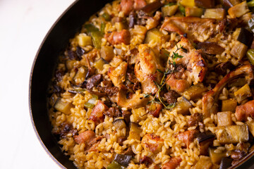 Spanish paella with rabbit, sausages, vegetables and artichokes. Traditional recipe from the Mediterranean area.