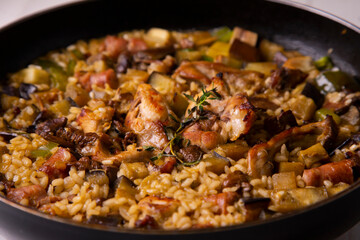 Spanish paella with rabbit, sausages, vegetables and artichokes. Traditional recipe from the Mediterranean area.