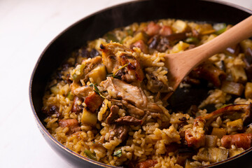 Spanish paella with rabbit, sausages, vegetables and artichokes. Traditional recipe from the Mediterranean area.