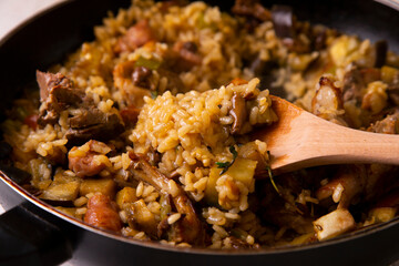 Spanish paella with rabbit, sausages, vegetables and artichokes. Traditional recipe from the Mediterranean area.
