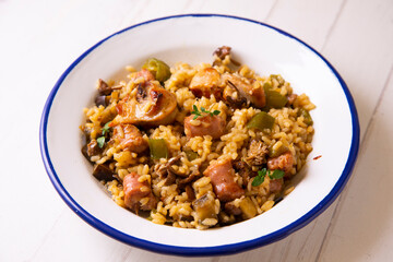 Spanish paella with rabbit, sausages, vegetables and artichokes. Traditional recipe from the Mediterranean area.