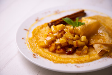 Mini crepes with apple compote and cinnamon. Traditional French recipe.