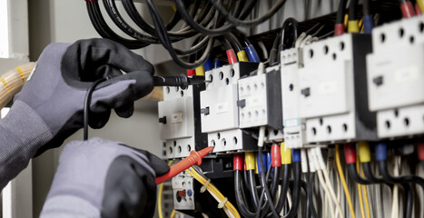 Electrician engineer tests electrical installations and wires on relay protection system....