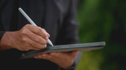 Business coach writing on his tablet with a pen