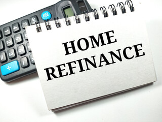 Finance concept.Text HOME REFINANCE on notebook with calculator on white background.